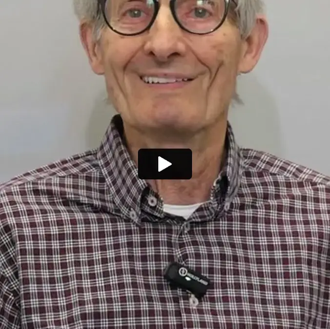 Paziente sorridente racconta in video la sua esperienza con i denti fissi su impianti.