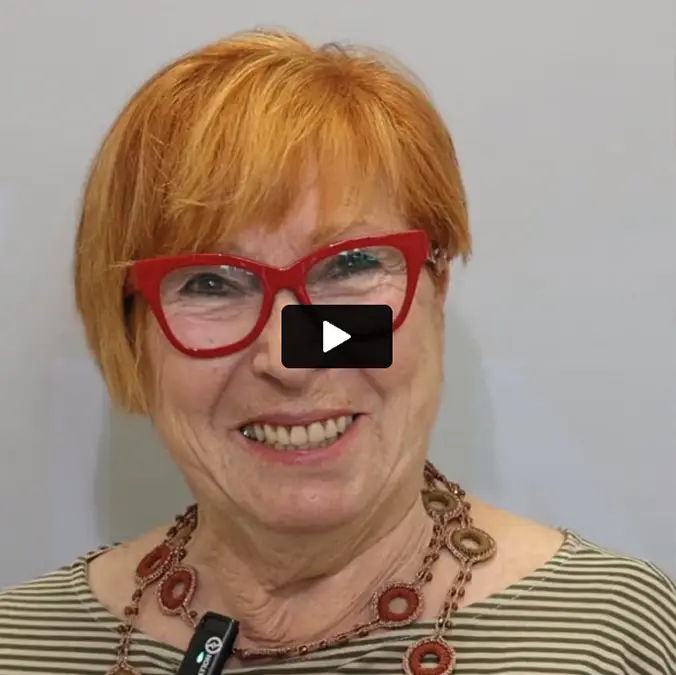 Paziente sorridente racconta in video la sua esperienza con gli impianti dentali.